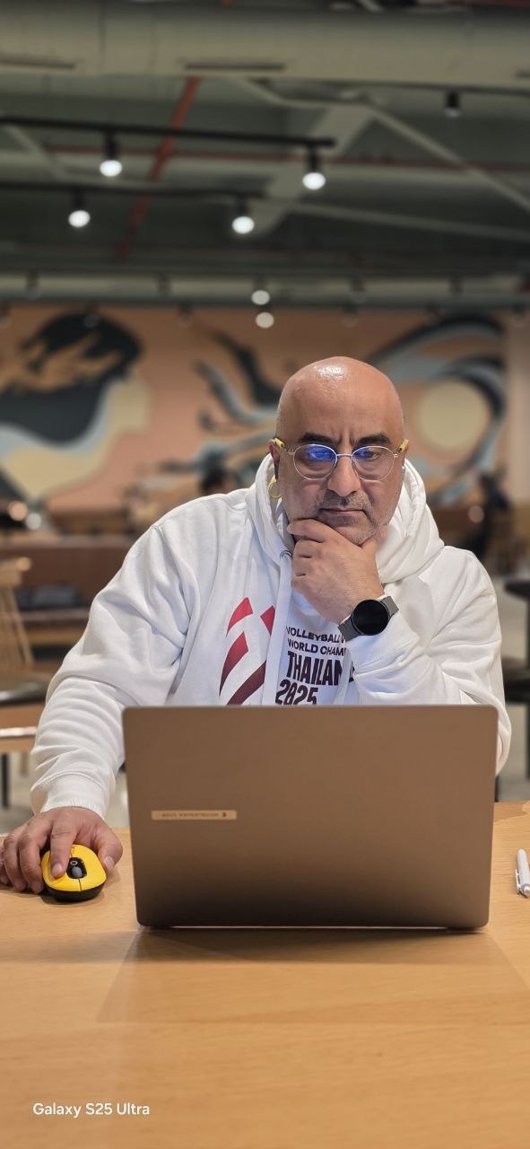 Hamed working on a laptop in a café
