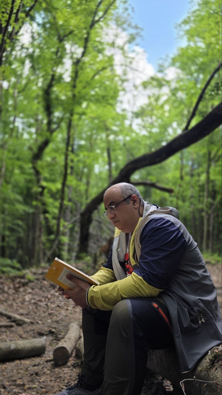 Hamed reading a book in the forest